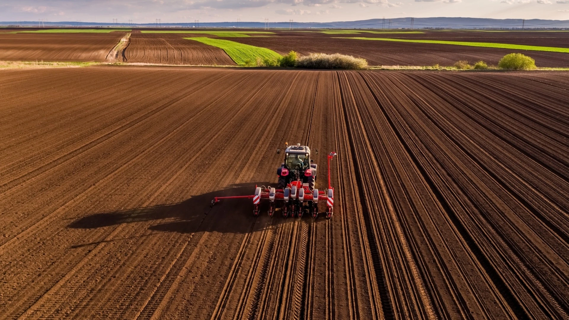Trator com plantador semeando sementes em uma paisagem rur