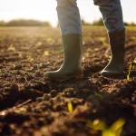 Close em pés de um agricultor